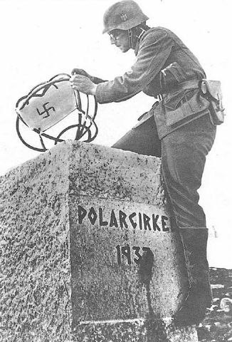 Soldado alemán colocando una bandera nazi en el obelisco que delimita el Círculo Polar Ártico en Noruega