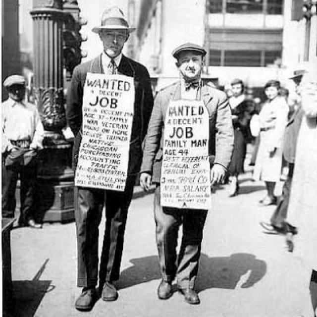 Dos ciudadanos pasean con sendos carteles en los que piden un trabajo decente