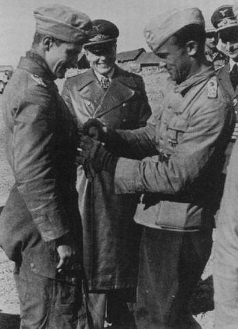 Marseille recibiendo la Cruz Alemana en oro de manos del comandante Edu Neumann En el centro el general Geisler