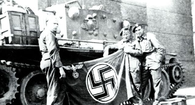 Fin del III Reich. Hombres de la 22ª Brigada de Tanques posan con una bandera nazi capturada junto a su tanque Cromwell